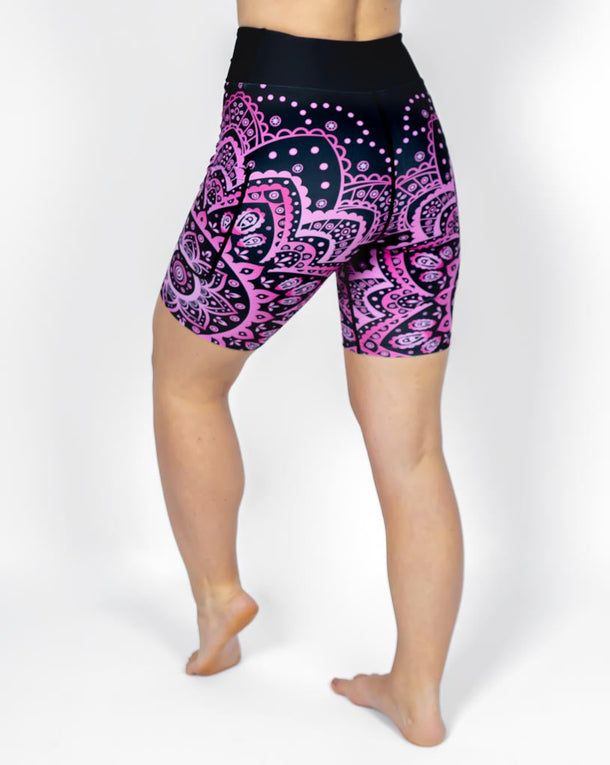 Kvinde i højtaljede mønstrede shorts. Shorts har lommer på begge sider. Meget elastiske og squat proof.