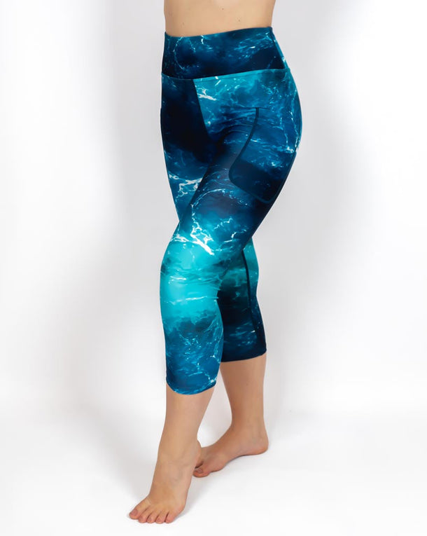 Kvinde i højtaljede mønstrede capris. Capris har lommer på begge sider. Meget elastiske og squat proof.