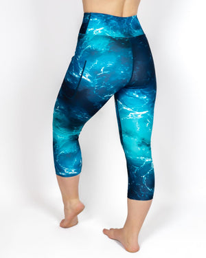 Kvinde i højtaljede mønstrede capris. Capris har lommer på begge sider. Meget elastiske og squat proof.