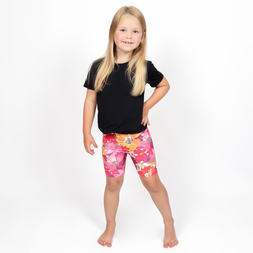 Barn i højtaljede mønstrede shorts. Meget elastiske og perfekt til leg og hverdag. Ikke gennemsigtige.