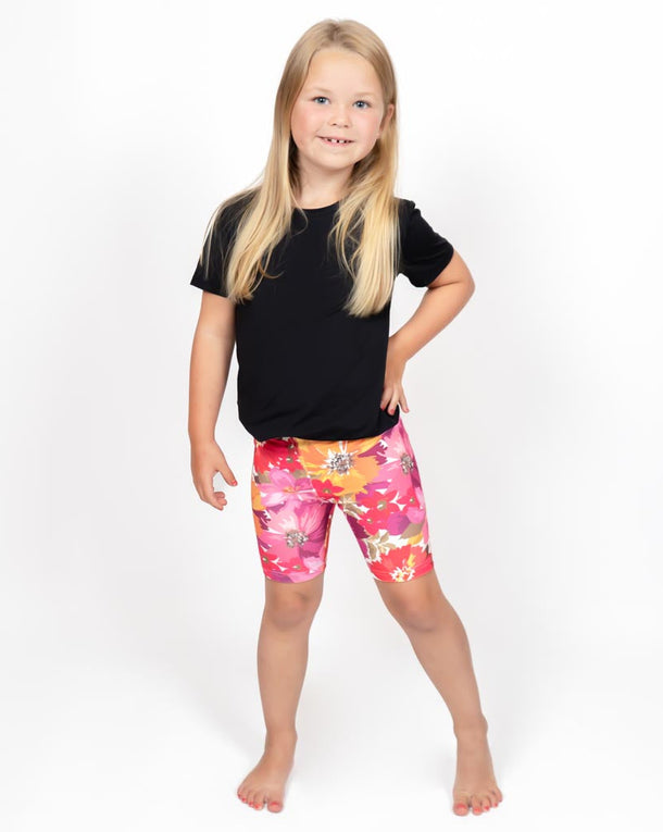 Barn i højtaljede mønstrede shorts. Meget elastiske og perfekt til leg og hverdag. Ikke gennemsigtige.