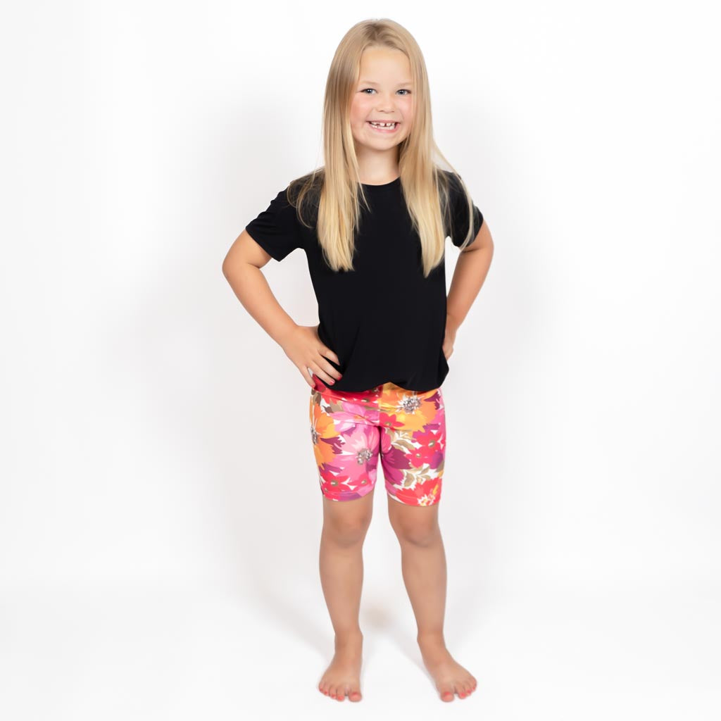 Barn i højtaljede mønstrede shorts. Meget elastiske og perfekt til leg og hverdag. Ikke gennemsigtige.