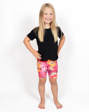 Barn i højtaljede mønstrede shorts. Meget elastiske og perfekt til leg og hverdag. Ikke gennemsigtige.