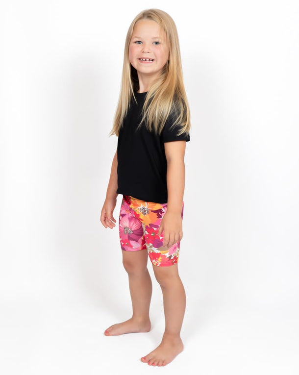 Barn i højtaljede mønstrede shorts. Meget elastiske og perfekt til leg og hverdag. Ikke gennemsigtige.