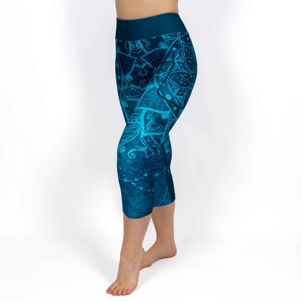 Kvinde i højtaljede mønstrede capris. Capris har lommer på begge sider. Meget elastiske og squat proof. 