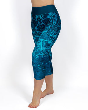 Kvinde i højtaljede mønstrede capris. Capris har lommer på begge sider. Meget elastiske og squat proof. 