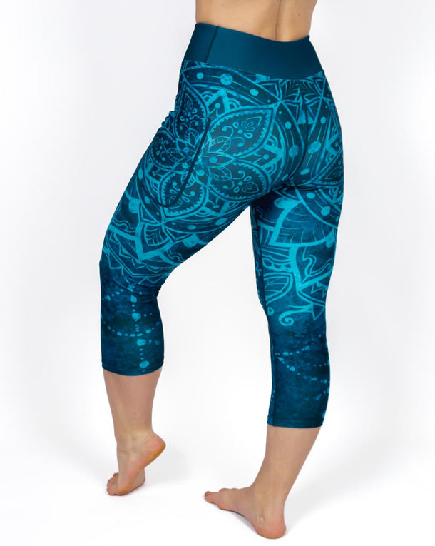 Kvinde i højtaljede mønstrede capris. Capris har lommer på begge sider. Meget elastiske og squat proof. 