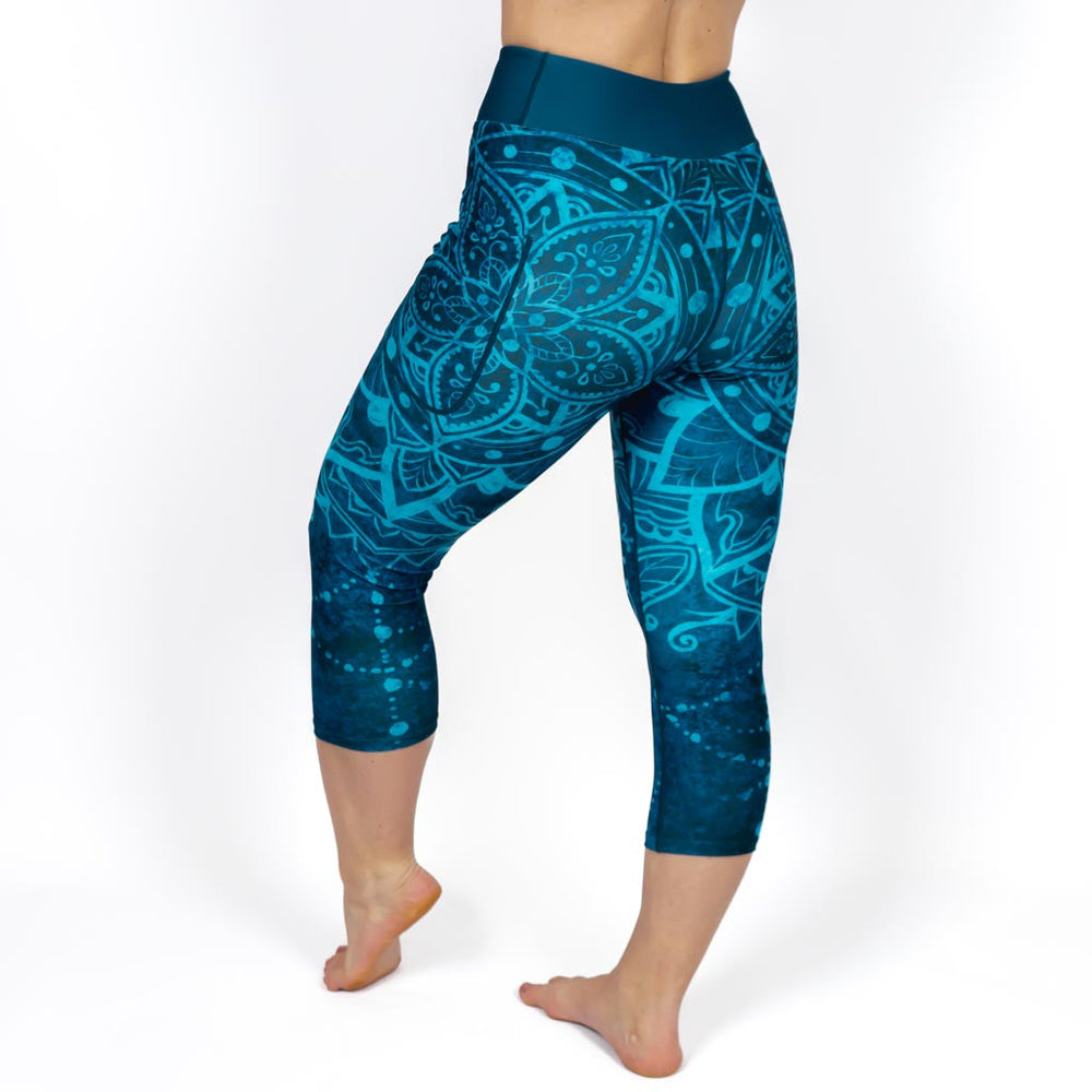 Kvinde i højtaljede mønstrede capris. Capris har lommer på begge sider. Meget elastiske og squat proof. 