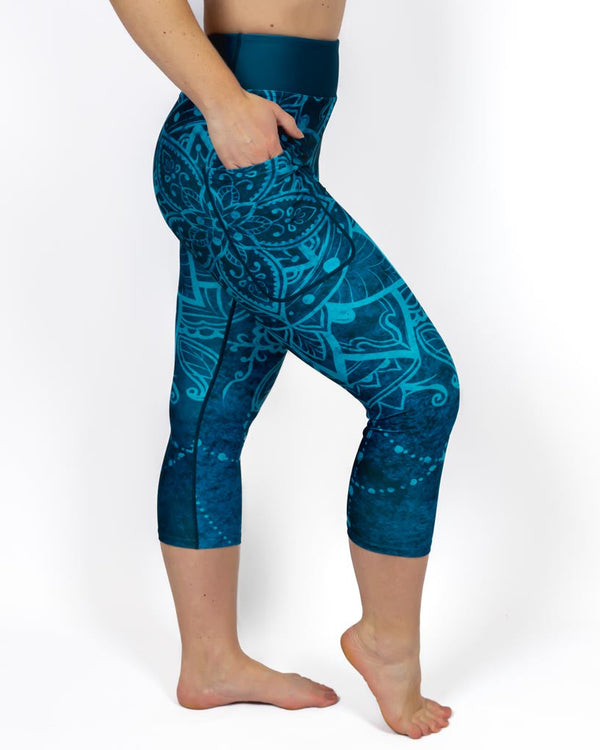 Kvinde i højtaljede mønstrede capris. Capris har lommer på begge sider. Meget elastiske og squat proof. 