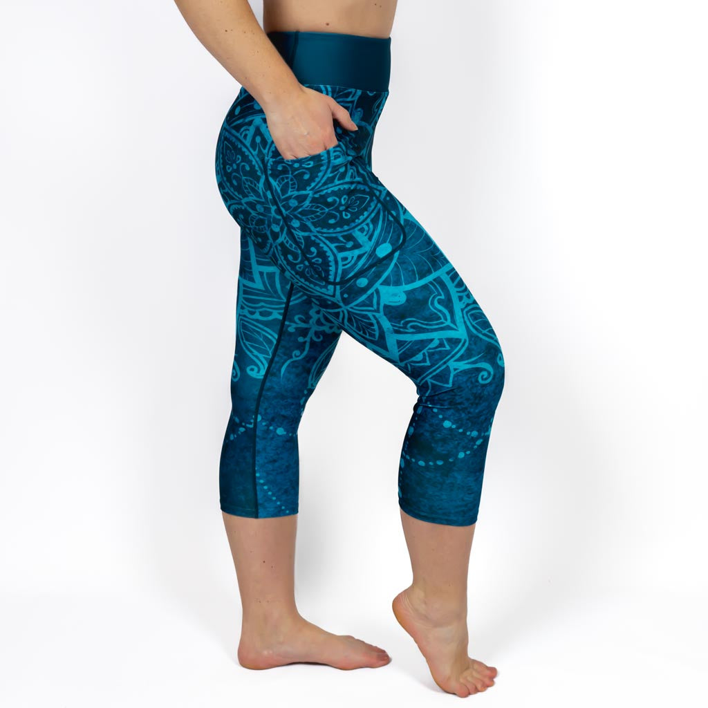 Kvinde i højtaljede mønstrede capris. Capris har lommer på begge sider. Meget elastiske og squat proof. 