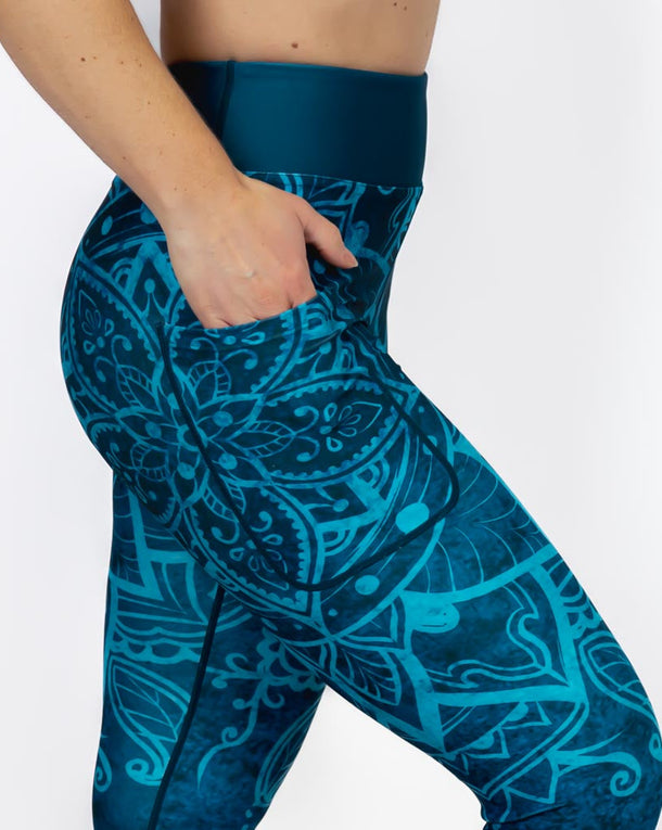 Kvinde i højtaljede mønstrede capris. Capris har lommer på begge sider. Meget elastiske og squat proof. 