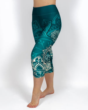 Kvinde i højtaljede mønstrede capris. Capris har lommer på begge sider. Meget elastiske og squat proof. 
