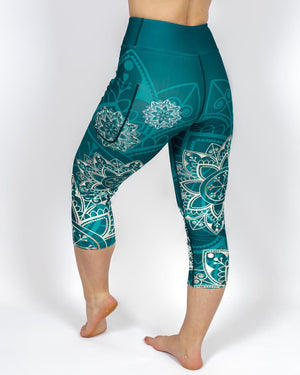 Kvinde i højtaljede mønstrede capris. Capris har lommer på begge sider. Meget elastiske og squat proof. 