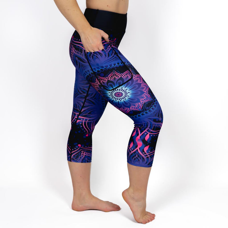 Kvinde i højtaljede mønstrede capris. Capris har lommer på begge sider. Meget elastiske og squat proof. 