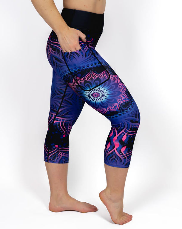 Kvinde i højtaljede mønstrede capris. Capris har lommer på begge sider. Meget elastiske og squat proof. 
