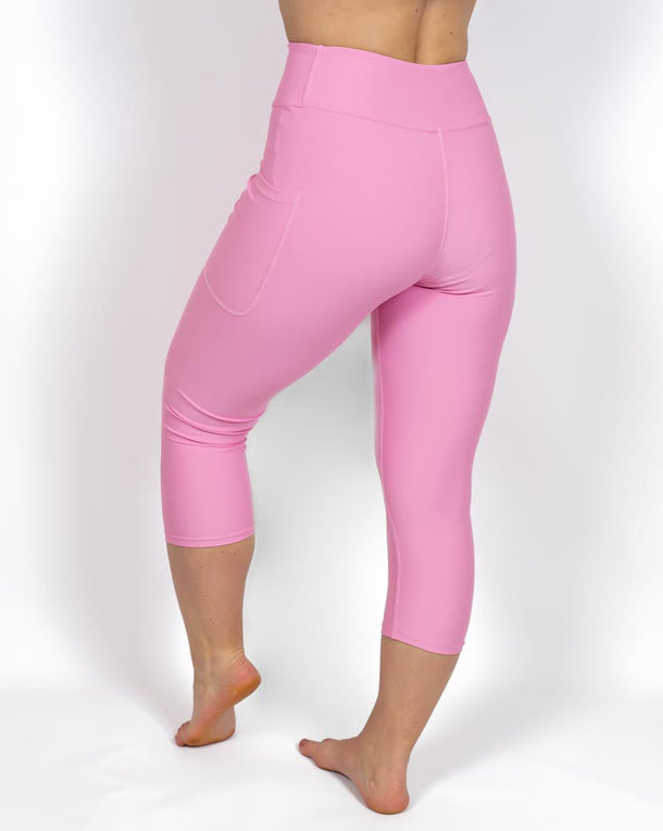 Kvinde i højtaljede ensfarvet capris. Capris har lommer på begge sider. Meget elastiske og squat proof. 
