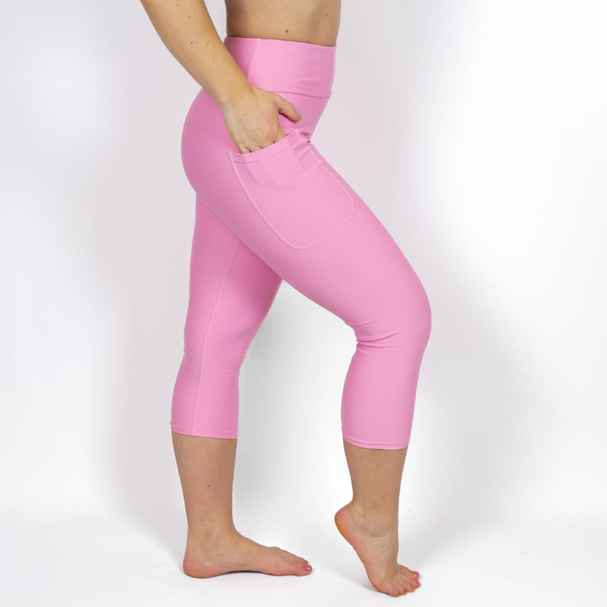 Kvinde i højtaljede ensfarvet capris. Capris har lommer på begge sider. Meget elastiske og squat proof. 