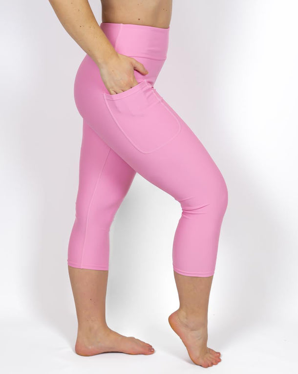 Kvinde i højtaljede ensfarvet capris. Capris har lommer på begge sider. Meget elastiske og squat proof. 