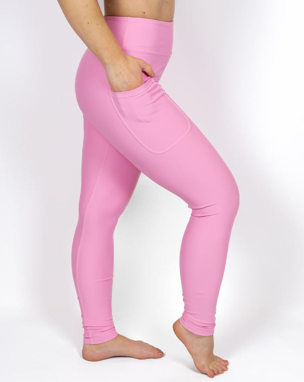 Kvinde i højtaljede ensfarvet leggings. Tights har lommer på begge sider. Meget elastiske og squat proof. 