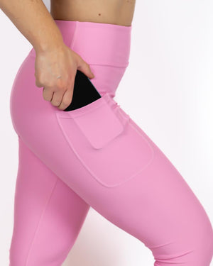 Kvinde i højtaljede ensfarvet capris. Capris har lommer på begge sider. Meget elastiske og squat proof. 
