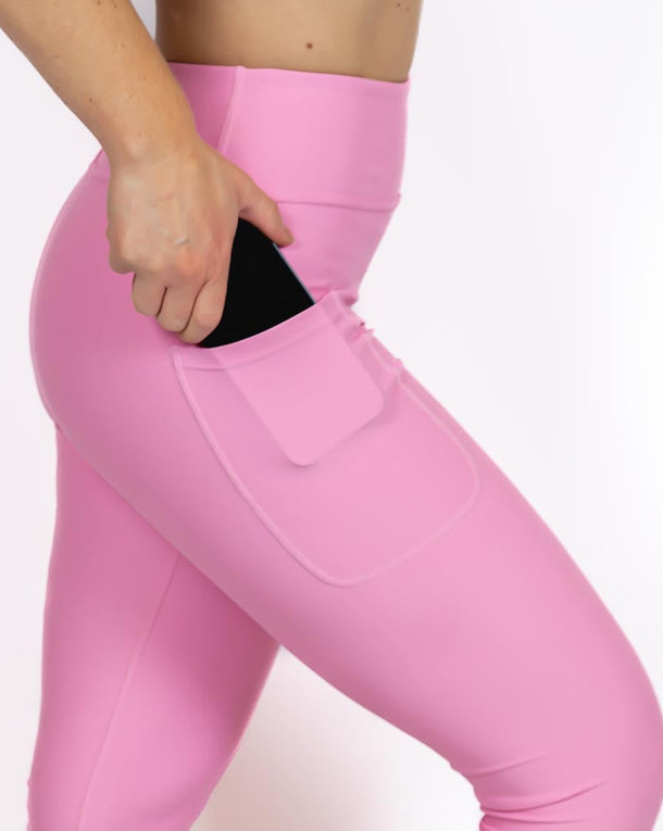 Kvinde i højtaljede ensfarvet capris. Capris har lommer på begge sider. Meget elastiske og squat proof. 