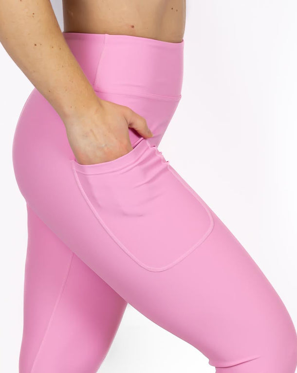 Kvinde i højtaljede ensfarvet leggings. Tights har lommer på begge sider. Meget elastiske og squat proof. 