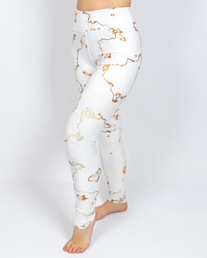 Kvinde i højtaljede mønstrede leggings. Tights har lommer på begge sider. Meget elastiske og squat proof.