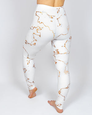 Kvinde i højtaljede mønstrede leggings. Tights har lommer på begge sider. Meget elastiske og squat proof.