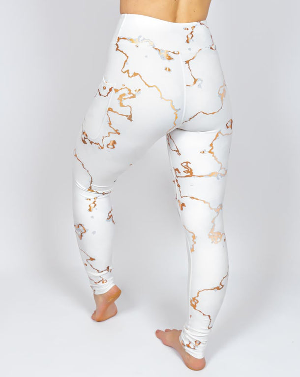 Kvinde i højtaljede mønstrede leggings. Tights har lommer på begge sider. Meget elastiske og squat proof.