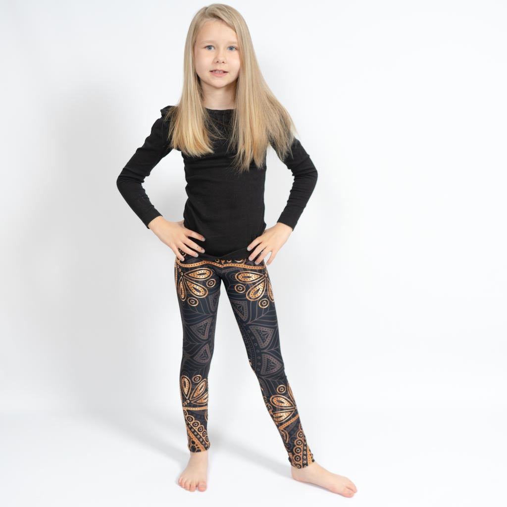 Barn i højtaljede mønstrede leggings. Meget elastiske og perfekt til leg og hverdag. Ikke gennemsigtige.